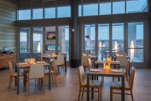 a restaurant with tables and chairs and large windows at Residence Inn by Marriott Baltimore at The Johns Hopkins Medical Campus in Baltimore