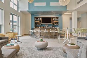 a lobby with a bar with chairs and a tv at Element Chattanooga East Marriott in Chattanooga