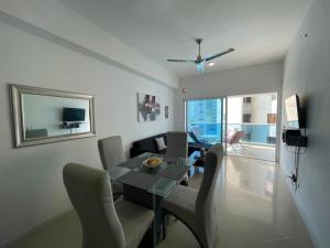 ein Wohnzimmer mit einem Tisch, Stühlen und einem Sofa in der Unterkunft Apartamento lujoso a un minuto de la playa del laguito, la mejor playa de Cartagena de Indias in Cartagena de Indias