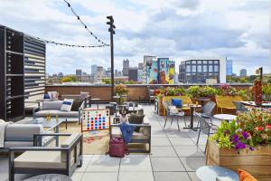 a patio with chairs and tables on a roof at Moxy Columbus Short North in Columbus