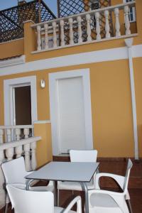 un comedor con mesas blancas y sillas blancas en Chalet adosado en Cullera