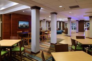 uma sala de jantar com mesas, cadeiras e colunas em Fairfield Inn & Suites by Marriott Newark Liberty International Airport em Newark