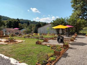 a garden with potted plants and a yellow umbrella at Appartement chaleureux de 82M2 proche de Vulcania in Pontaumur