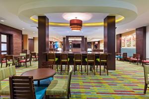 a restaurant with tables and chairs and a bar at Fairfield Inn and Suites by Marriott Austin Northwest/Research Blvd in Austin