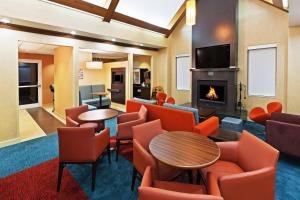 a hotel lobby with a fireplace and chairs and a table at Residence Inn Houston Sugar Land/Stafford in Stafford