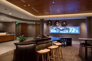 a lobby with a bar with stools and a tv at SpringHill Suites by Marriott Kalispell in Kalispell