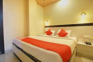 1 dormitorio con 1 cama grande con almohadas rojas en Hotel Rj Grand, en Coimbatore