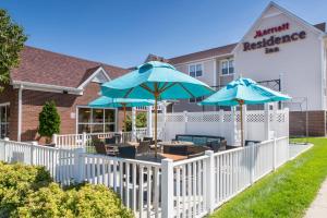 Residence Inn Sioux Falls في شلالات سيوكس: مطعم فيه مظلات زرقاء على سياج ابيض