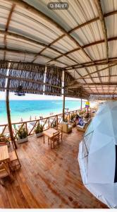 una sombrilla abierta en una playa con el océano en La Cabaña Glamping Geronimo, en Playa Blanca