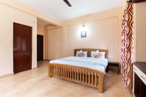 een slaapkamer met een groot bed in een kamer bij OYO Home Vedica Home Stays in Ambalavayal