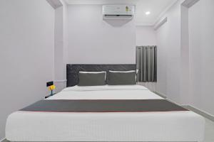 Un dormitorio blanco con una gran cama blanca. en Collection O Hotel Chirag StayÃƒÂ©Ã‹â€ Ã‚Â¥ÃƒÂ¦Ã‚ÂªÃ…Â¡, en Hyderabad