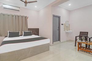 1 dormitorio con 1 cama grande y 1 silla en Collection O Hotel Chirag StayÃƒÂ©Ã‹â€ Ã‚Â¥ÃƒÂ¦Ã‚ÂªÃ…Â¡, en Hyderabad