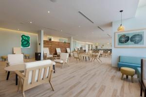 a waiting room with chairs and tables and a blue couch at Residence Inn by Marriott Cancun Hotel Zone in Cancún