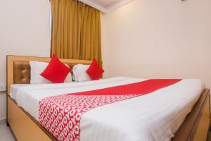 a bedroom with a large bed with red pillows at Hotel Orbit Inn Near Infiniti Mall in Mumbai