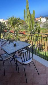 a table and chairs on a balcony with a cactus at Villa in vetro in Castellammare del Golfo