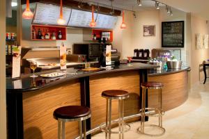 a bar in a restaurant with stools at a counter at Courtyard by Marriott Fort Lauderdale East / Lauderdale-by-the-Sea in Fort Lauderdale