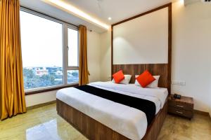 1 dormitorio con 1 cama grande y ventanas grandes en Maurya Inn en Jodhpur