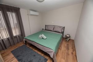 um quarto com uma cama com um edredão verde em Seacoast apartments 3 ! em Kamena Vourla