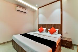 1 dormitorio con 1 cama grande con almohadas de color naranja en Maurya Inn en Jodhpur