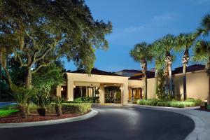 a house with palm trees and a driveway at Courtyard by Marriott Jacksonville at the Mayo Clinic Campus/Beaches in Jacksonville
