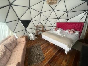 a room with a bed and a couch and a wall at La Cabaña Glamping Geronimo in Playa Blanca
