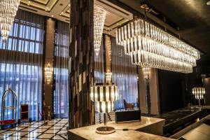 a lobby with chandeliers and a table in a building at Iris Hotel Baku - Halal Hotel in Baku