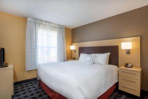 una camera d'albergo con un grande letto e una finestra di TownePlace Suites Huntsville a Huntsville