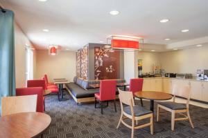 un restaurante con mesas y sillas y un sofá en TownePlace Suites Huntsville, en Huntsville