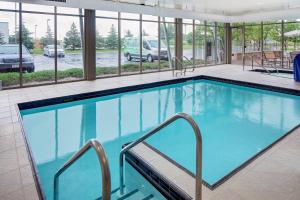a large swimming pool in a building with windows at SpringHill Suites Green Bay in Green Bay
