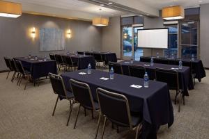 een conferentieruimte met tafels en stoelen en een scherm bij SpringHill Suites Green Bay in Green Bay