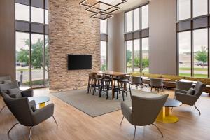 a conference room with a table and chairs and a tv at SpringHill Suites Green Bay in Green Bay