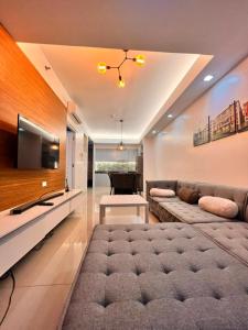 een woonkamer met een groot bed en een televisie bij The Pearl Interior Designed 1 BR Unit Burgos Circle BGC in Manilla