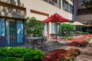 a patio with tables and umbrellas in front of a building at Detroit Marriott Livonia in Livonia