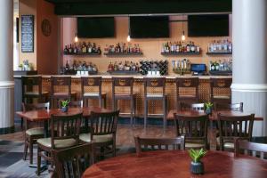 a restaurant with wooden tables and chairs and a bar at Detroit Marriott Livonia in Livonia