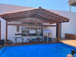 a wooden pergola over a swimming pool at La Cabaña Glamping Geronimo in Playa Blanca