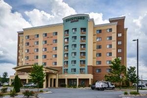 um hotel com um carro estacionado num parque de estacionamento em Courtyard Charlotte Concord em Concord