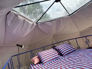 een bed in een tent met twee kussens erop bij Stay Classy - Domes in Otterlo