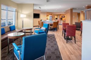 a waiting room with blue chairs and a table at TownePlace Suites by Marriott Gainesville in Gainesville