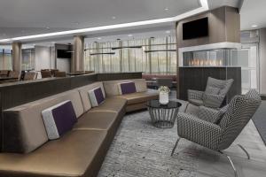 a lobby with a couch and chairs and a bar at SpringHill Suites by Marriott East Rutherford Meadowlands Carlstadt in Carlstadt