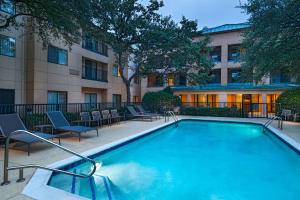 a swimming pool in front of a building at Courtyard by Marriott Dallas Plano in Legacy Park in Plano