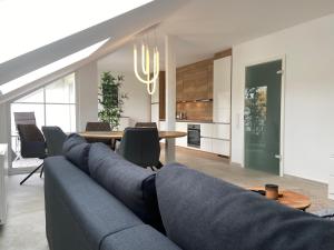 a living room with a blue couch and a table at Ferienwohnung Westerwaldblick Haiger in Haiger