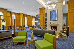 Courtyard by Marriott Nashville Green Hills في ناشفيل: لوبي وكراسي خضراء وموقد