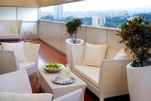 a balcony with chairs and a bowl of fruit on a table at Marriott Executive Apartments Addis Ababa in Addis Ababa