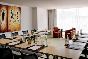 una sala de conferencias con mesas, sillas y una pintura en Marriott Executive Apartments Addis Ababa en Addis Abeba