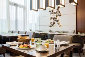 Marriott Executive Apartments Kuwait City في الكويت: غرفة طعام مع طاولة عليها طعام