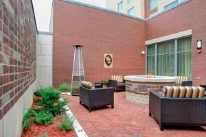 a patio with chairs and a hot tub next to a brick building at Courtyard by Marriott Muncie at Horizon Convention Center in Muncie