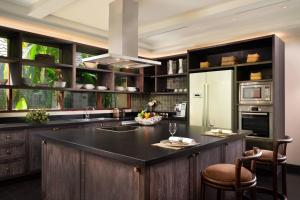 a kitchen with a black counter top and a refrigerator at Mandapa, a Ritz-Carlton Reserve in Ubud