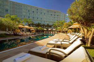 a hotel pool with lounge chairs and a resort at Le Meridien Cairo Airport in Cairo