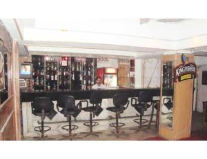 a bar with black bar stools in a room at Hotel Swagat, Jammu in Jammu