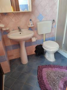 a bathroom with a white toilet and a sink at Villa in vetro in Castellammare del Golfo +10 photos
